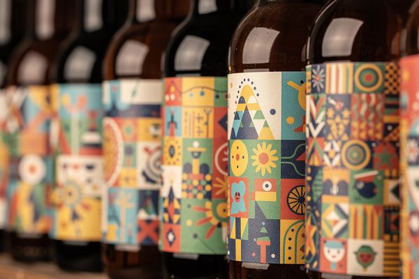 Close-up of craft beer bottle labels lined up on a shelf